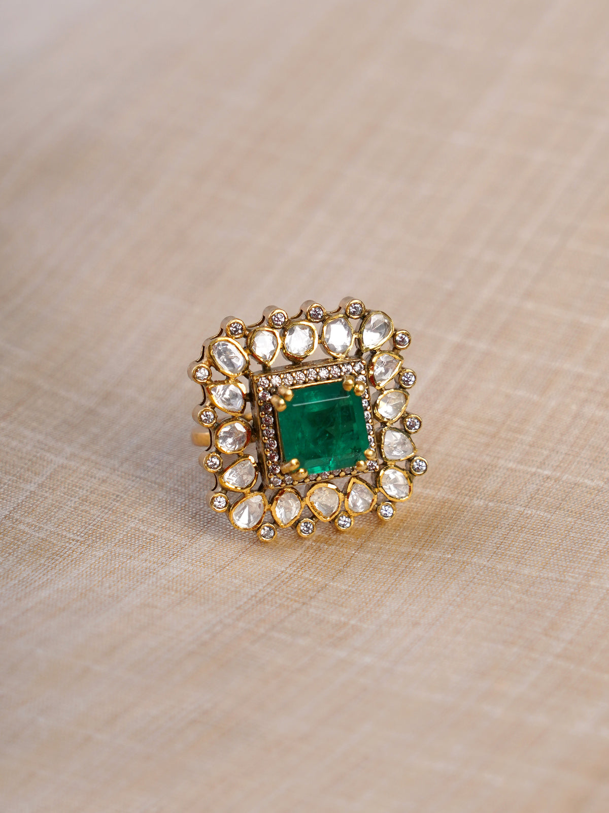 Samragni emerald square kundan polki statement ring shown on hand with green centre stone and white teardrop halo