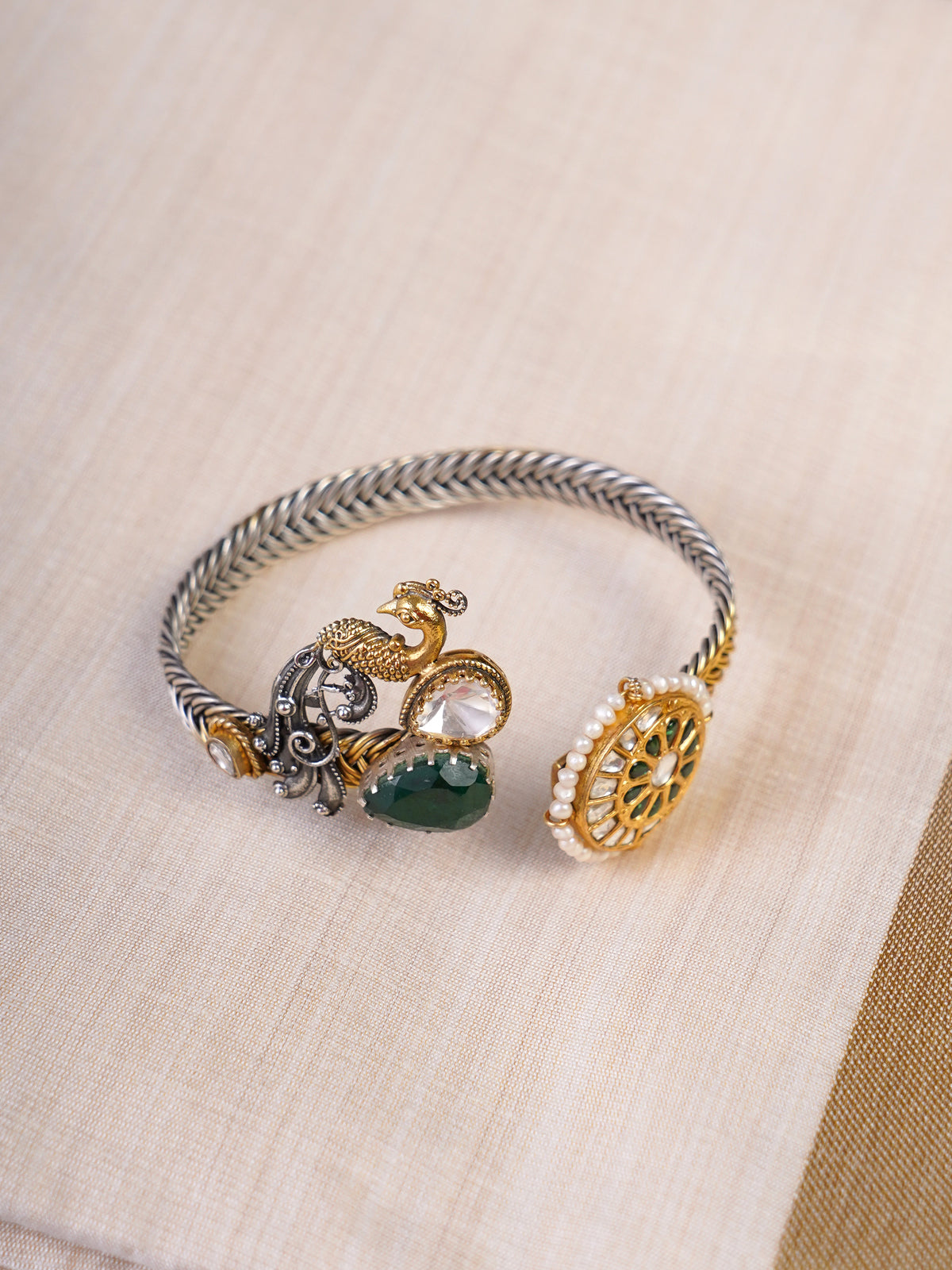 Sitamahor peacock green stone fusion cuff shown from an alternate angle on a silver textile background