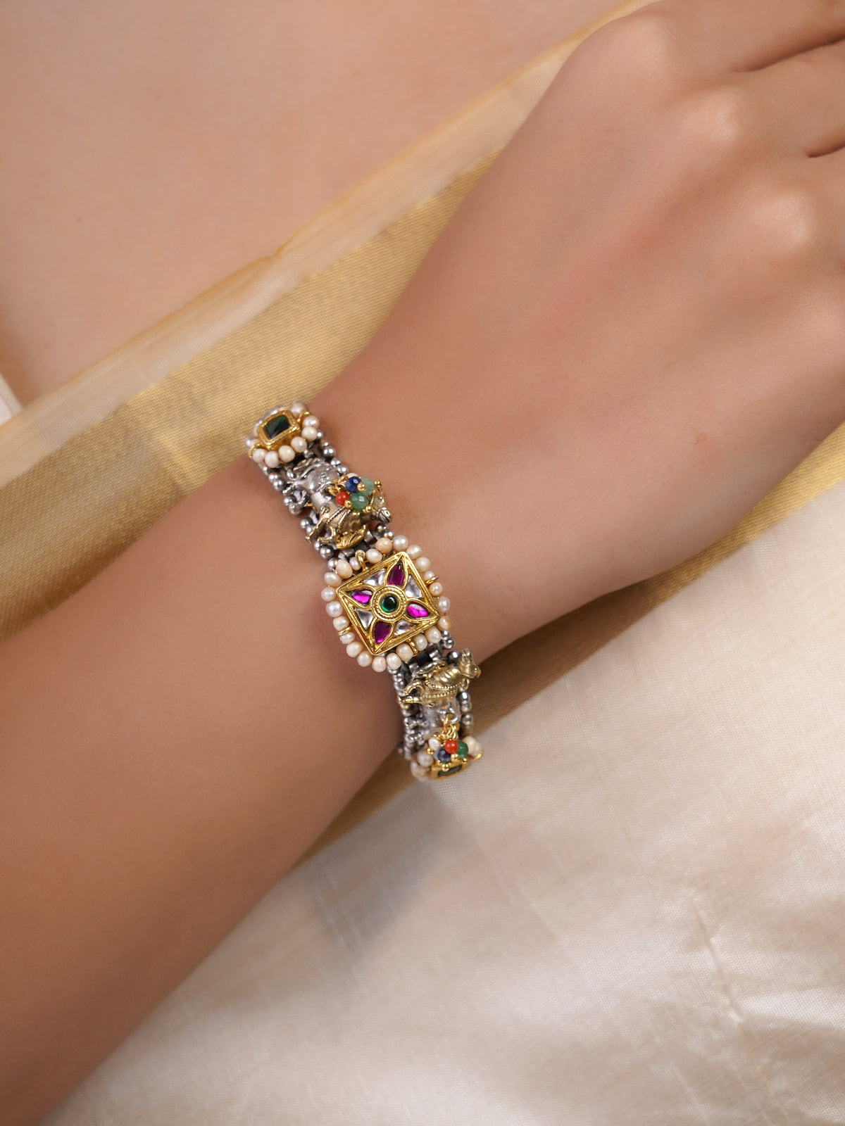 Samragni Rajwada square kundan pearl jadau bracelet styled on the wrist with pink, green and dual-tone detailing