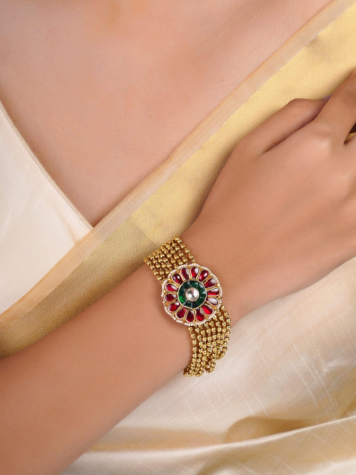 Samragni red and green floral kundan bead bracelet shown flat with multi-strand gold-tone beads