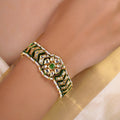 Samragni green meena kundan pearl bracelet shown flat with white stones, green accents and pearl border