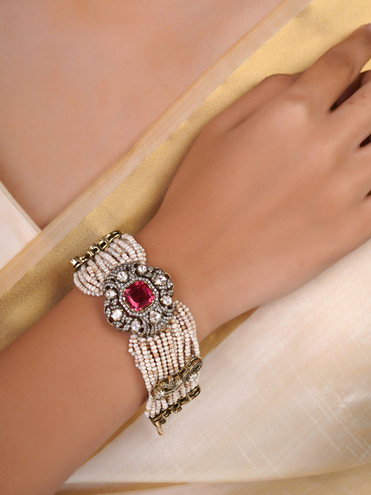 Sitaratna ruby pink pearl and moissanite statement bracelet shown flat with layered pearl strands and ornate central setting