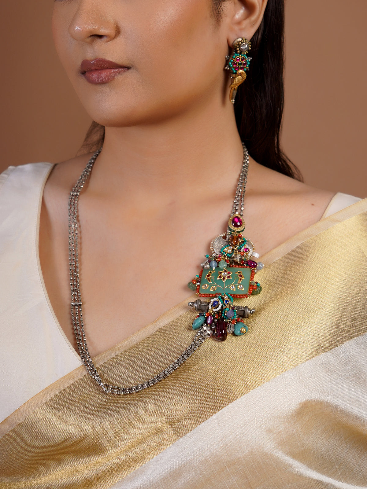 Close view of Sitamahor Navrangi fusion necklace with silver chain strands turquoise enamel panel ruby accents and bead drops