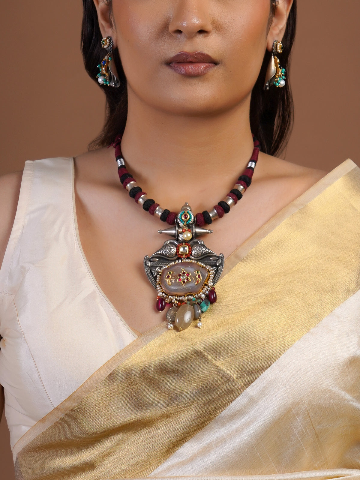 Close view of Sitamahor fusion pendant necklace with maroon black cord bird motifs pearl edging and multicolour stone drops