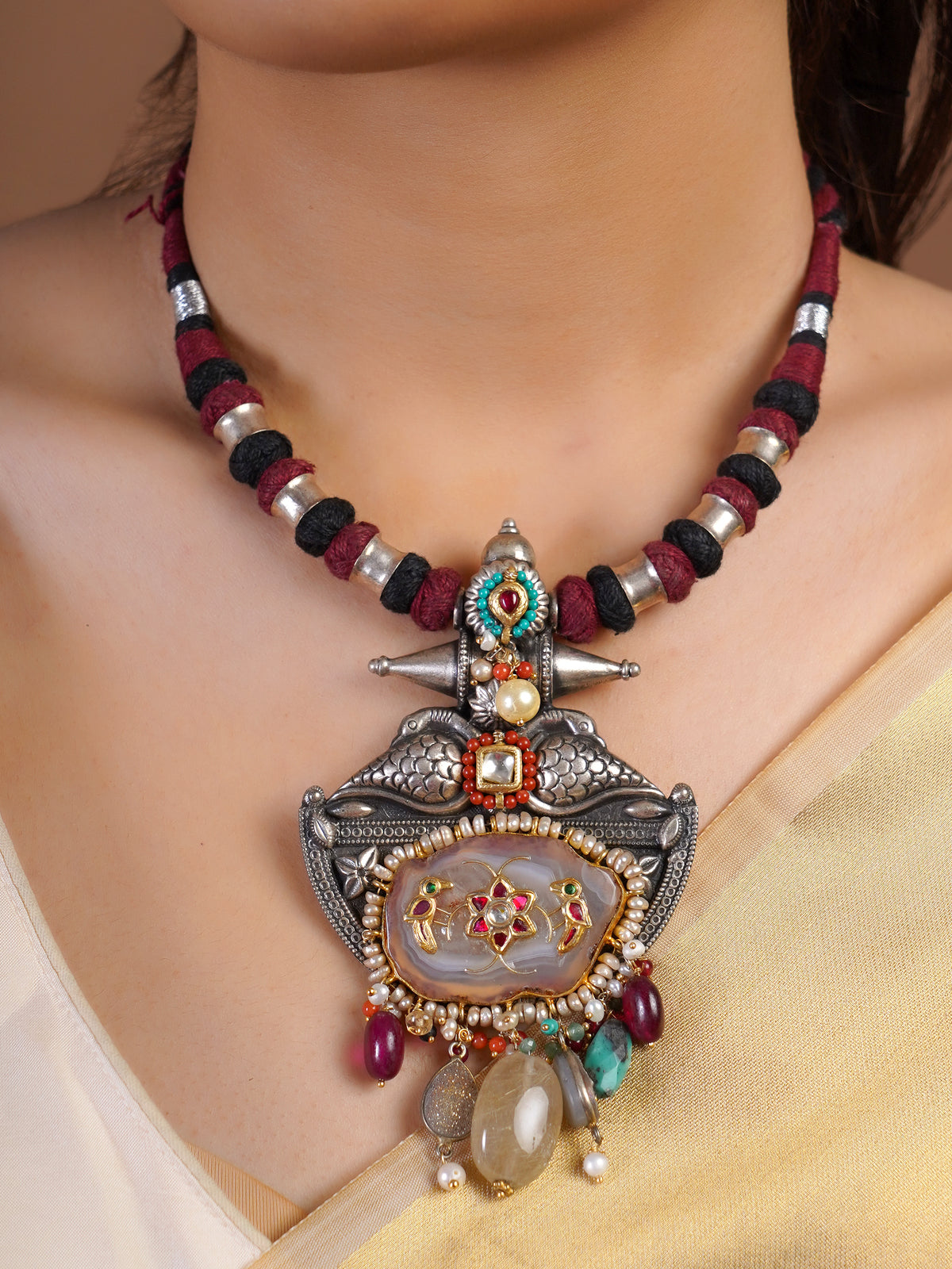 Sitamahor bird stone panel textile cord fusion necklace styled with ivory saree and sculptural mixed-media pendant