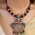 Sitamohur bird stone panel textile cord fusion necklace styled with ivory saree and sculptural mixed-media pendant