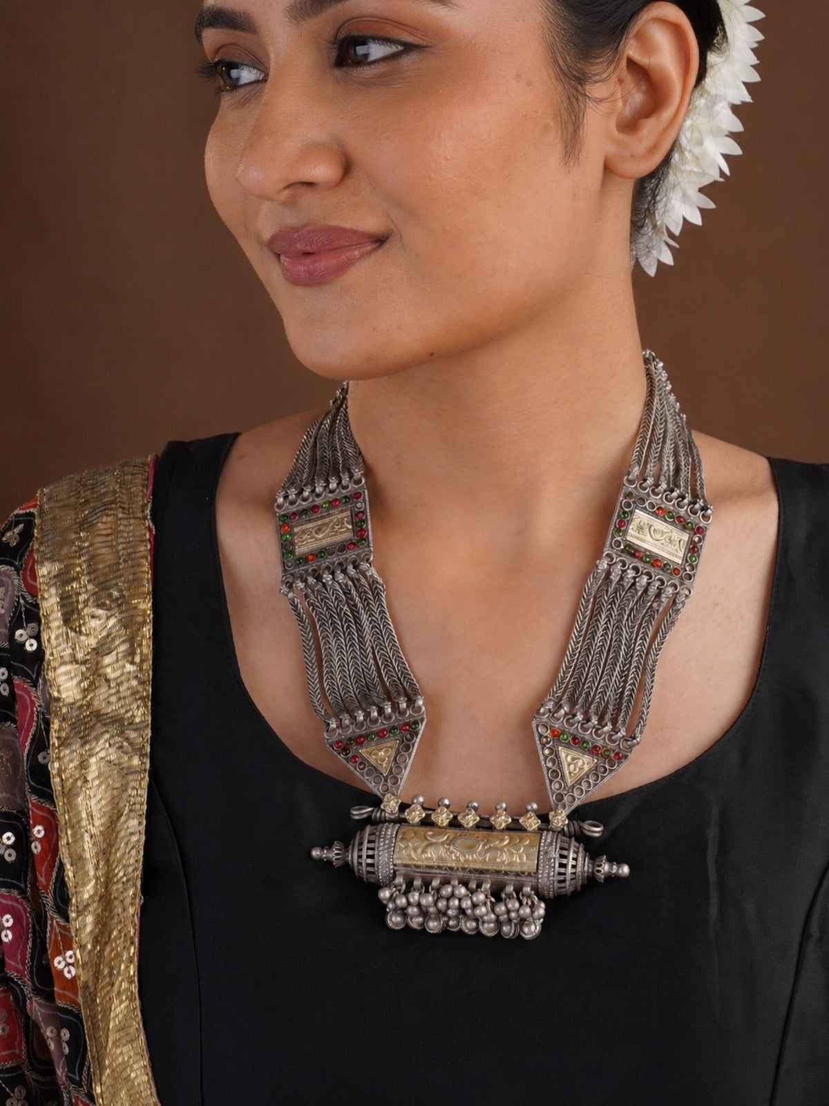 Close view of Sitavan oxidized tribal necklace with braided chains geometric panels red green accents and ghungroo centre pendant