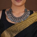 Sitavan floral coin heart fringe oxidized collar necklace styled with black saree and matching silver-tone jhumkas