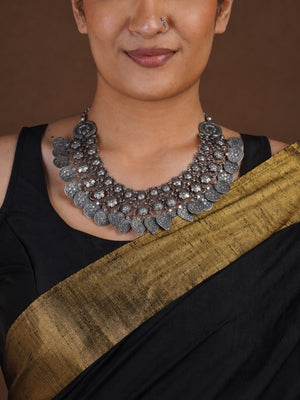 Sitavan floral coin heart fringe oxidized collar necklace styled with black saree and matching silver-tone jhumkas