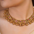 Samragni antique gold temple collar necklace with ruby pink green stone accents and layered embossed heritage motifs