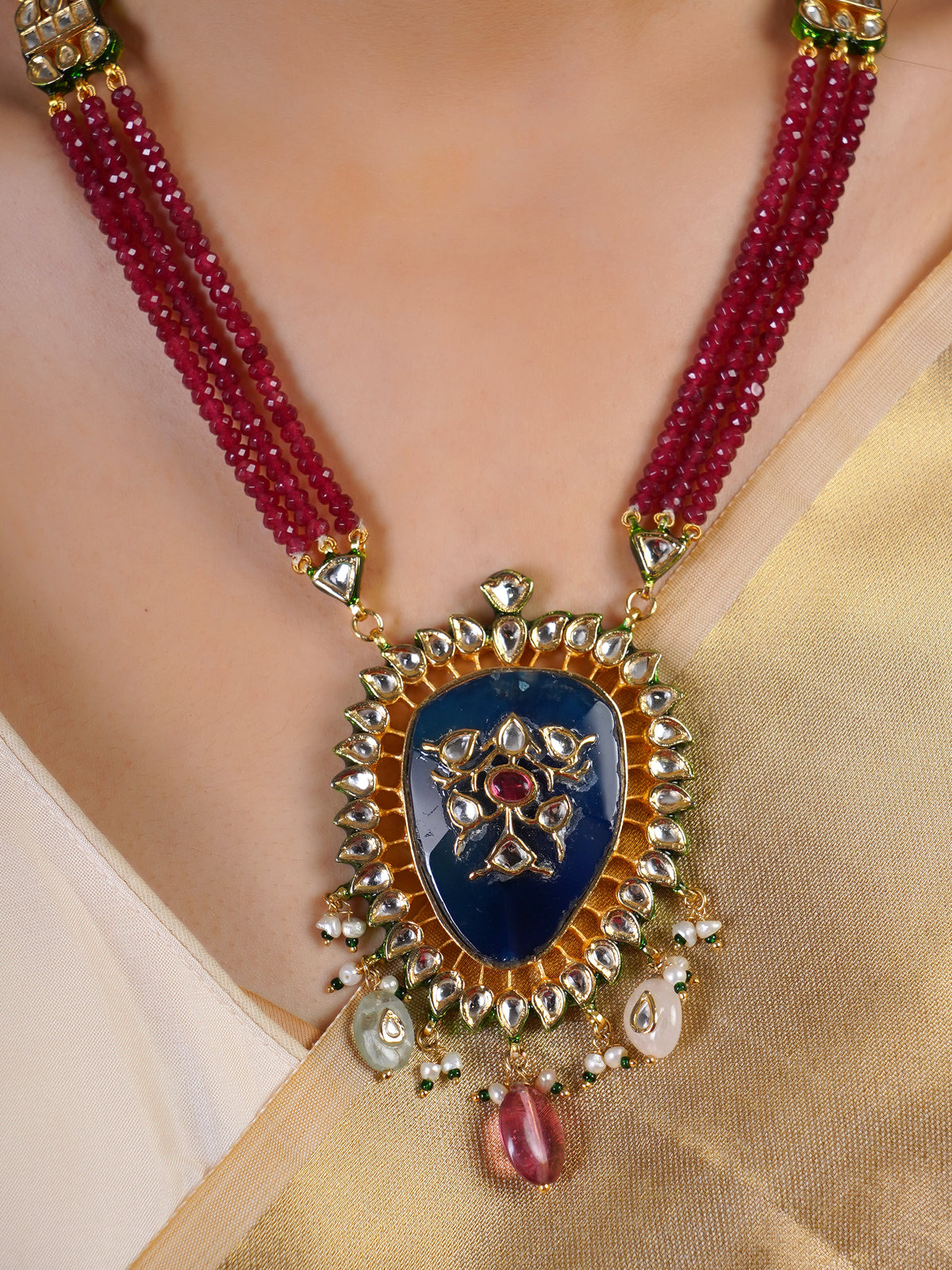 Samragni ruby bead necklace pendant close-up with deep blue centre, kundan-style white stone halo and gemstone drops