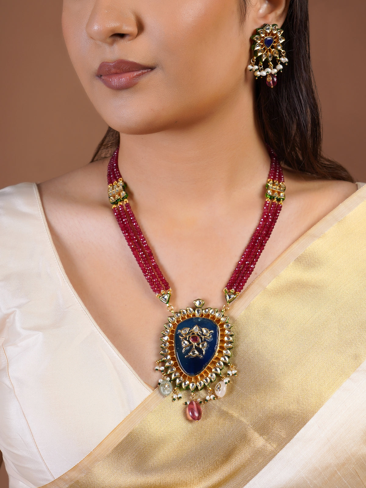 Samragni blue kundan statement earring close-up with floral white stone frame, pearl clusters and ruby drop