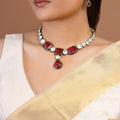 Samraagni ruby red and white kundan necklace set with green enamel-style borders, central drop and matching earrings