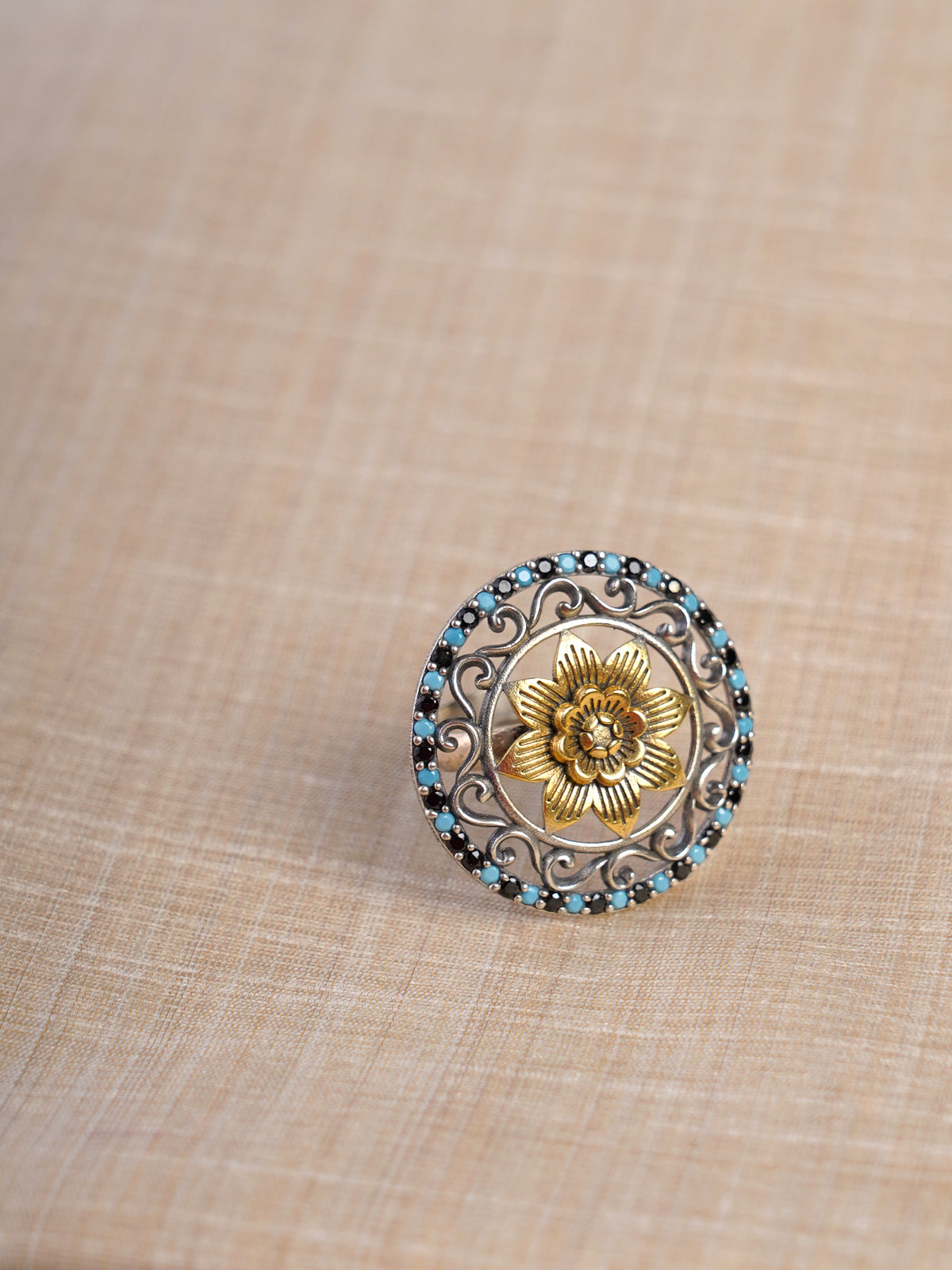 Sitamahor turquoise floral dual-tone fusion statement ring shown on hand with round oxidized silver and gold design