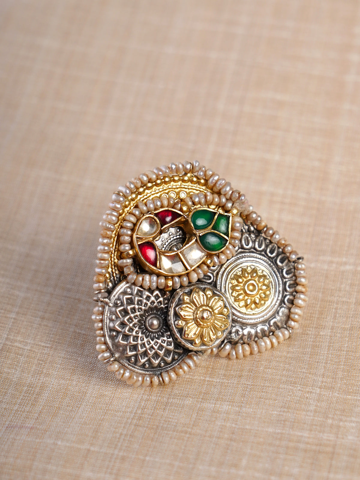 Sitamohur navrangi pearl fusion statement ring shown on hand with layered silver-gold floral medallions and red green details
