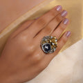 Sitamahor dual-tone floral fusion statement ring with large faceted midnight-black gemstone, crystal halo and mixed silver-gold metalwork
